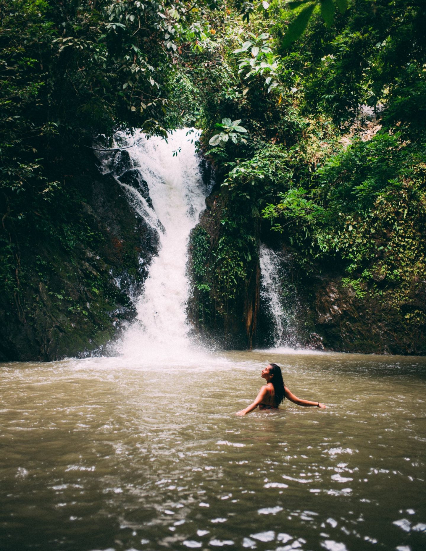 women swimming in waterfall